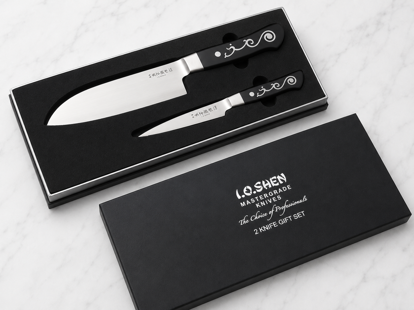 Two stainless-steel kitchen knives with black decorative handles in a black gift box with foam insert.