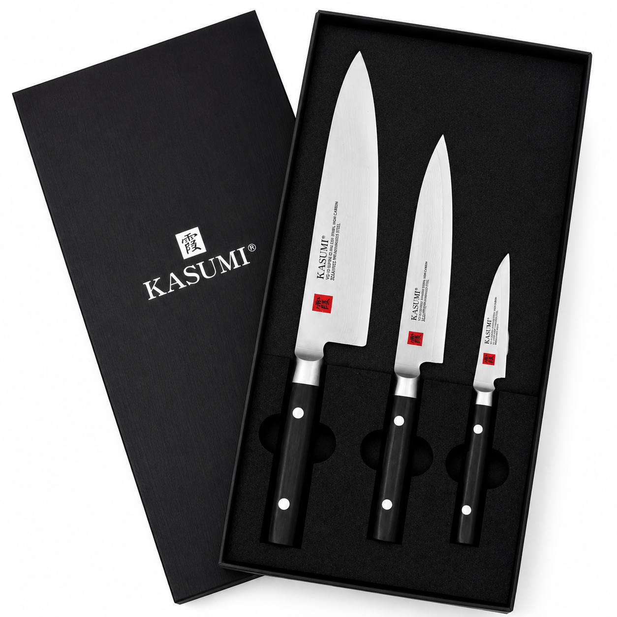 Set of three Kasumi kitchen knives in a black presentation box with foam insert and white logos on blades from Kasumi Japanese brand.
